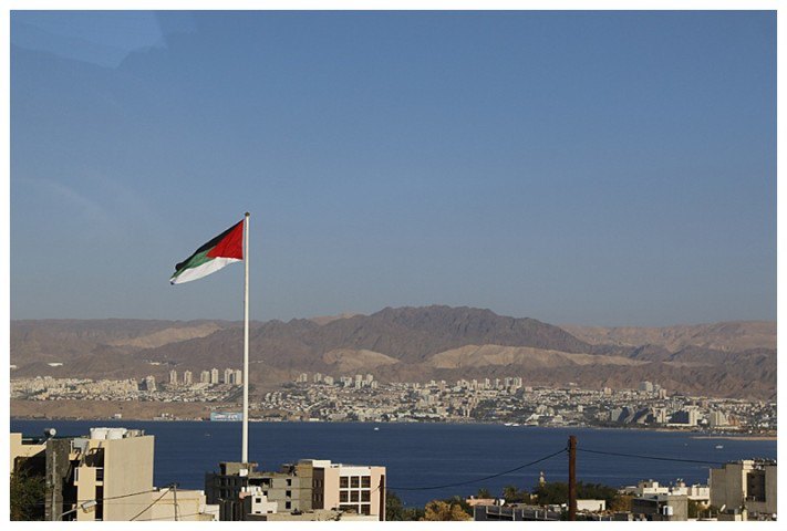 A massive Jordanian flag, so large that it can be seen from Israel, in the background.