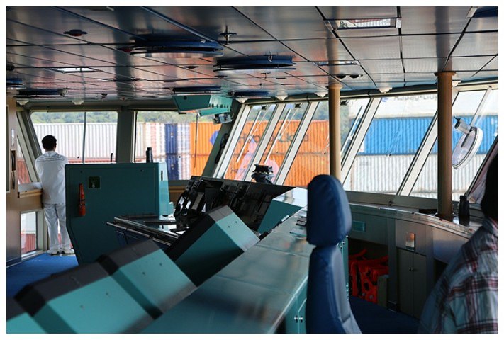 Out on the opposite bridge-wing, all that can be seen are the containers on the deck of a passing ship