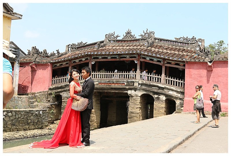 A couple having their wedding photos taken, the Phung Hung ancient bridge as a backdrop.