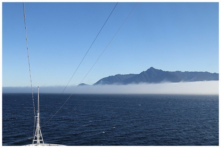 The top of Kuiu Island looms above the fog bank