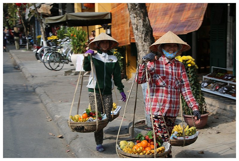 Vegetable and fruit sellers carrying their wares
